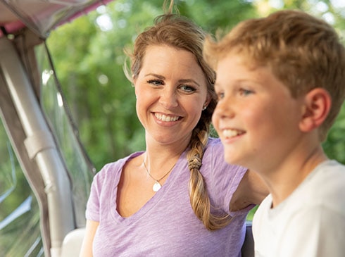 Close-up of smiling mother and son riding in back of Pink Jeep on the Roaring Fork Smoky Mountains tour