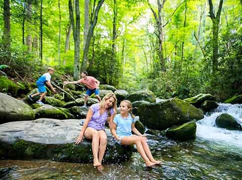 Family playing in stream on along Roaring Fork Motor Nature trail, Great Smoky Mountains National Park