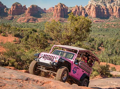A customized Pink® Jeep® navigates Sedona's rugged desert terrain on the Broken Arrow tour