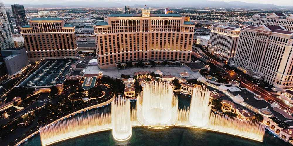 Aerial view of The Fountains of Bellagio during dusk with the casino resort in the background.