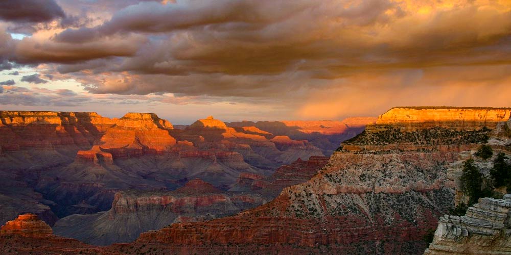 Vibrant, fiery orange sunset over the Grand Canyon's South Rim.