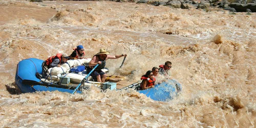 Grand Canyon river guide and guests rafting along the whitewater rapids of the Colorado River.