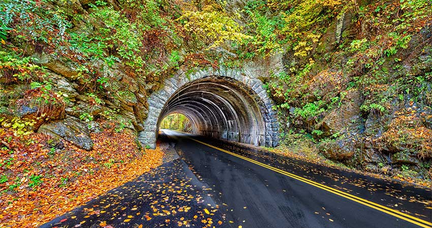 A landmark Smoky Mountains Tunnel between Townsend, TN and Cades Cove Valley surrounded by a spray of autumn colors.