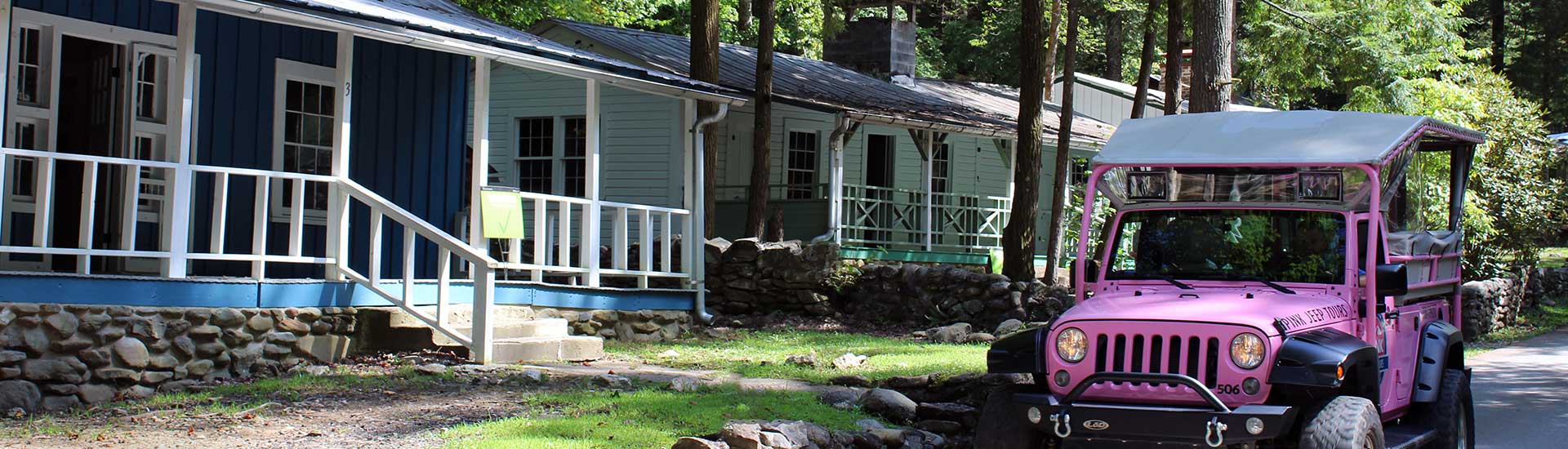 Pink Jeep Wangler driving past the newly restored cabins in Daisy Town, Elkmont Ghost Town, Tennessee.