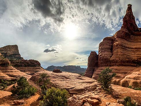 Scenic view from Sedona's Chicken Point overlook with sun glowing through the clouds, Pink Jeep Tours Sedona, AZ.