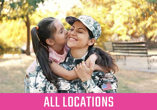 Daughter hugging and kissing mother in military uniform.