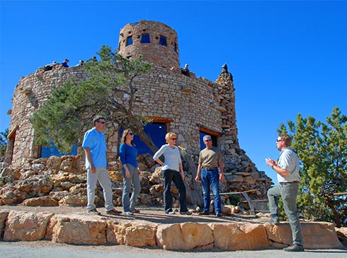 Pink Jeep Tours Grand Canyon guide talking with tour guests in front of the east side of the Desert View Watchtower, Grand Canyon National Park, USA.