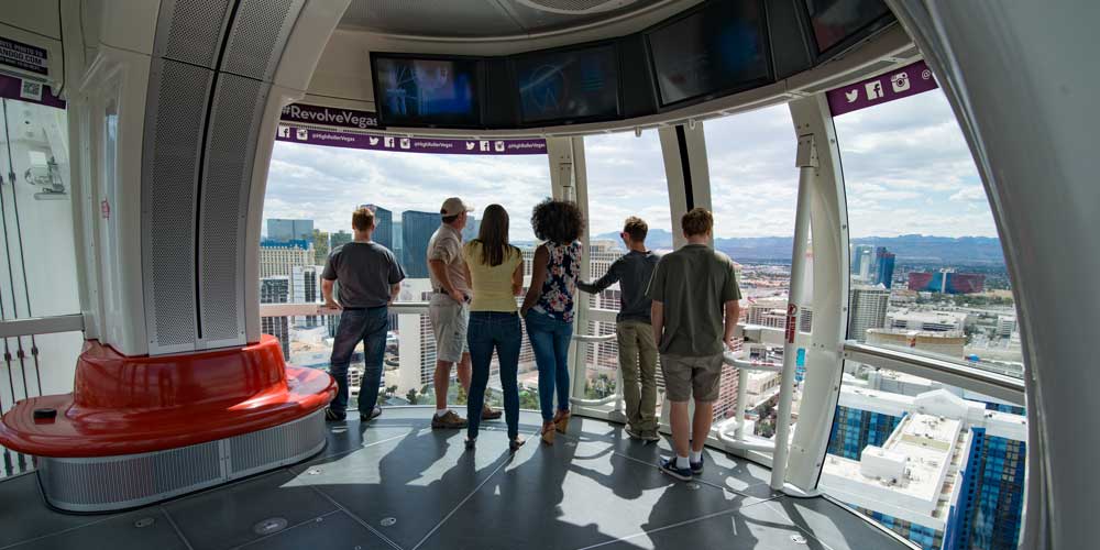 Group of people looking outside the windows of the observation deck of the Las Vegas High Roller.