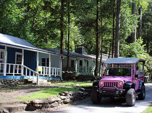 Pink Jeep Wrangler driving through Daisy Town, Elkmont Ghost Town in the Smoky Mountains.